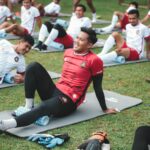 Orang berlari di taman pagi dengan pakaian olahraga, menampilkan kebugaran dan semangat berolahraga.