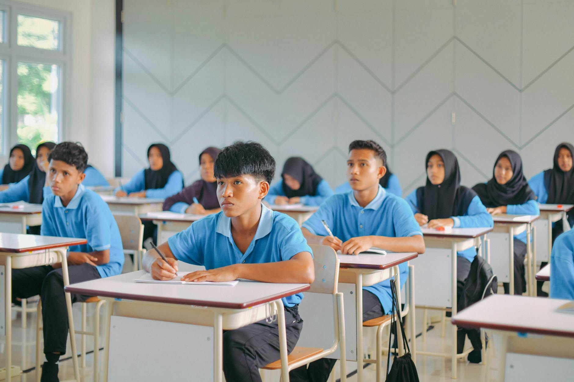 Siswa bersemangat belajar di kelas modern dengan teknologi digital, mencerminkan masa depan pendidikan Indonesia.