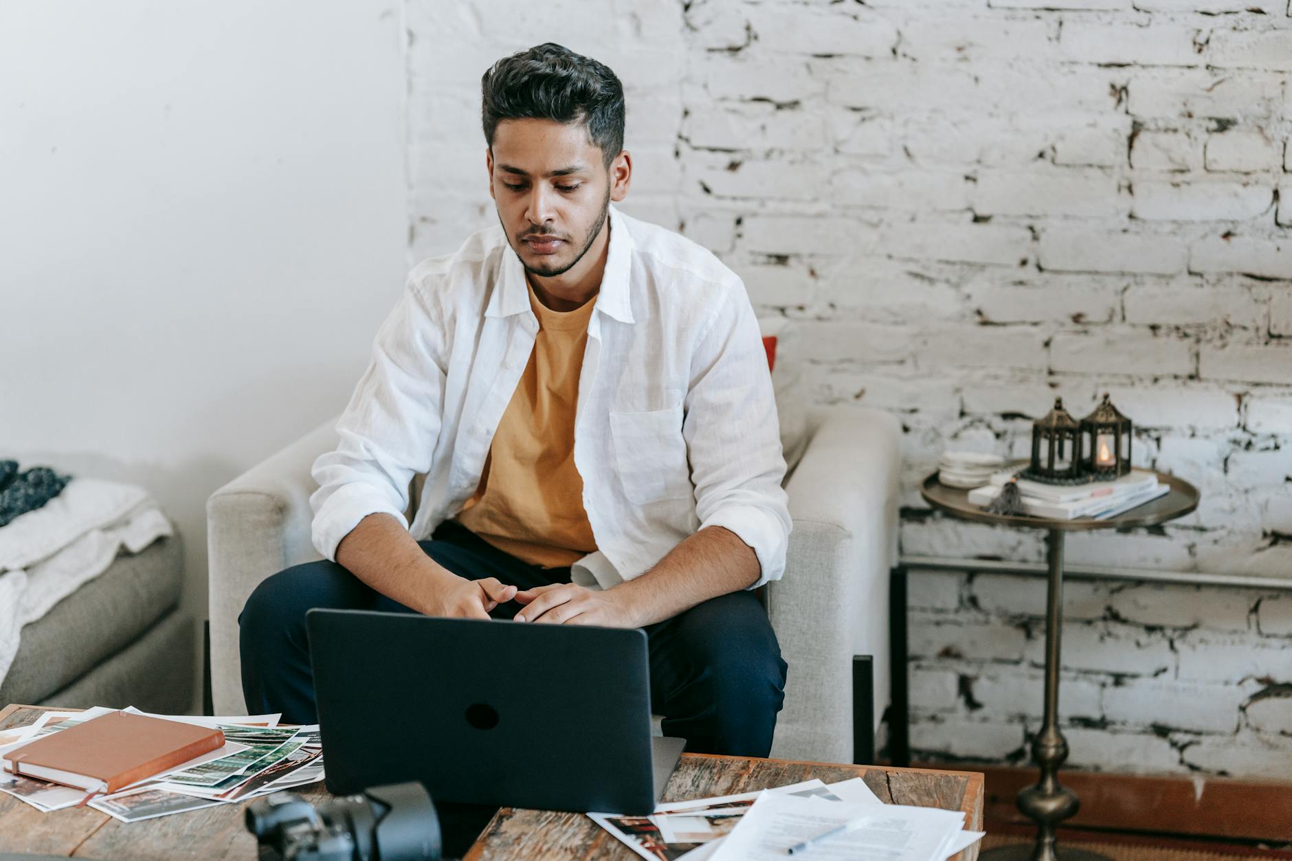 Desainer grafis bekerja dari kafe, menunjukkan kebebasan kerja freelance dengan laptop.